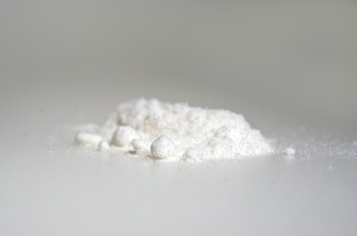 alpha arbutin chemical powder on whitish background