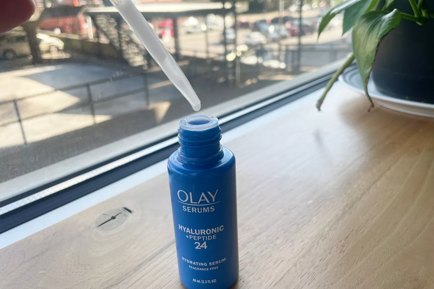 A person holds the dropper on the OLAY Hyaluronic + Peptide 24 Serum